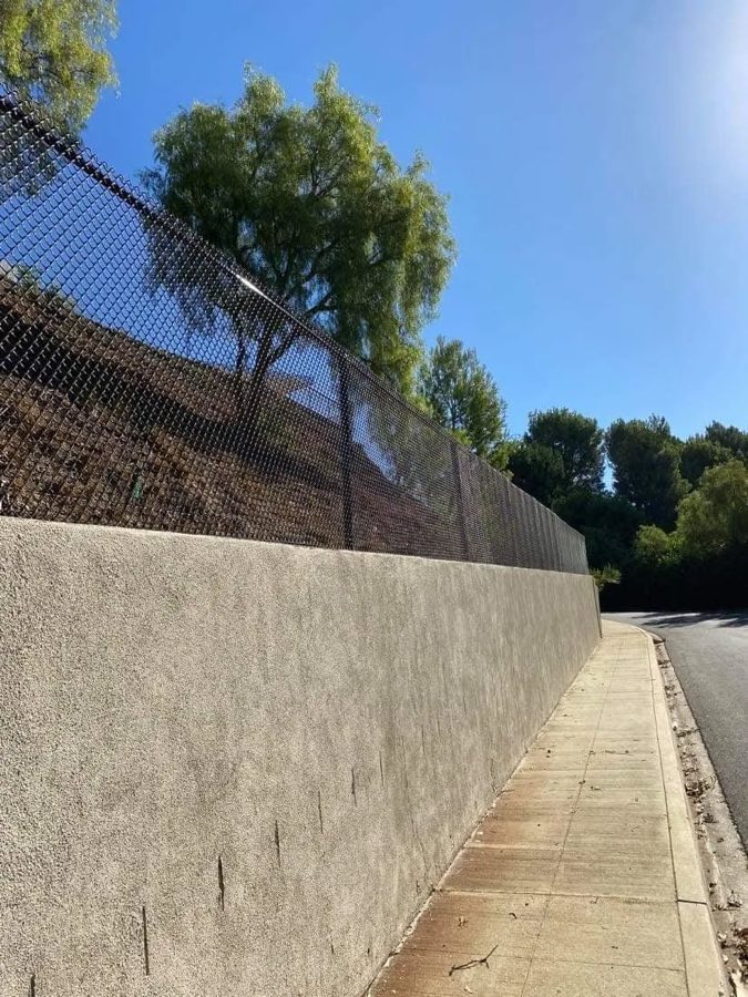 Chain link fence installed above a concrete retaining wall