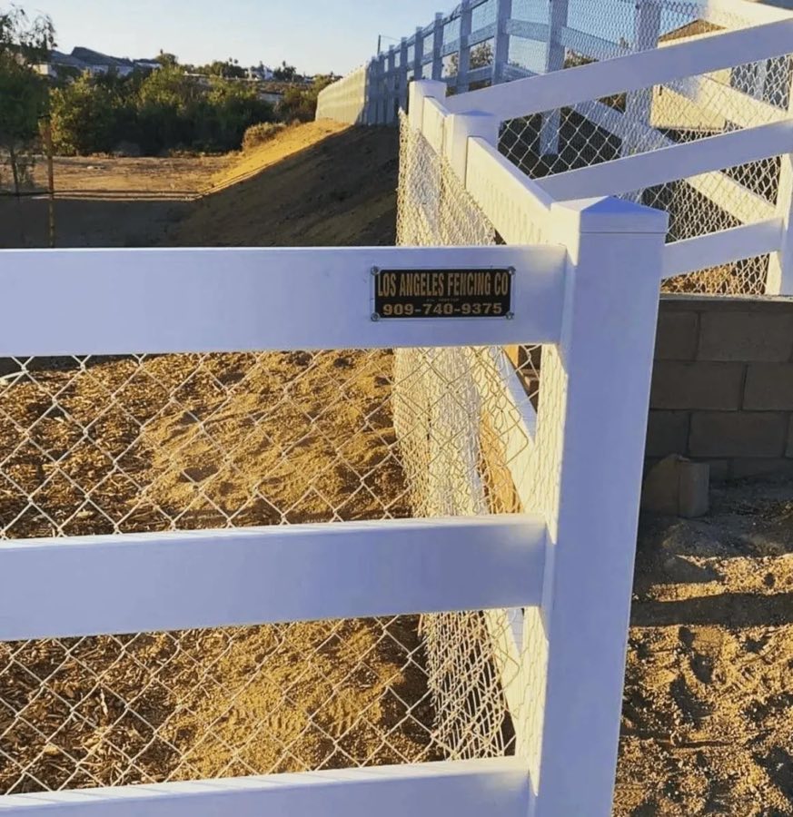 White rail fence with chain link backing