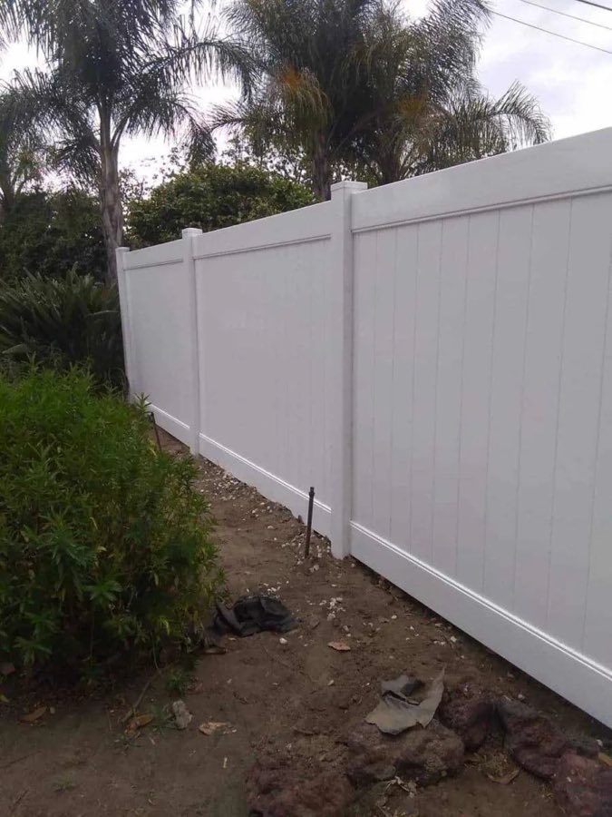 White vinyl privacy fence with palm trees